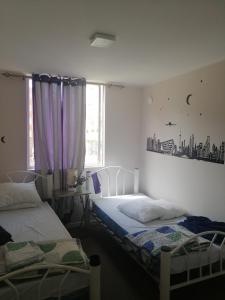 een slaapkamer met 2 bedden en een raam met uitzicht op de stad bij DEPTO EN PUERTAS DEL MAR in La Serena