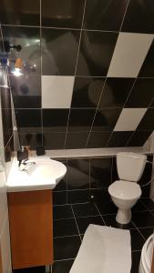 czarno-biała łazienka z toaletą i umywalką w obiekcie Aare kodumajutus Sandri tuba w mieście Tammiku