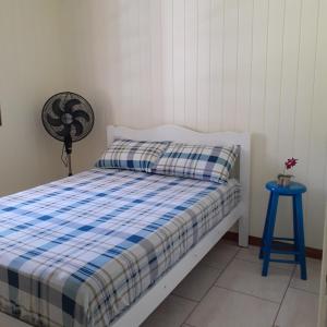 um quarto com uma cama e um banco azul em Meu pedacinho de chão em Serra Negra