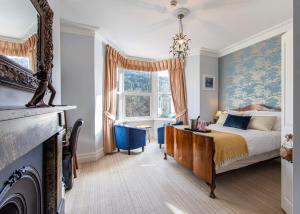 a bedroom with a king sized bed and a fireplace at Afon View in Betws-y-coed