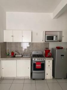 a kitchen with a stove and a refrigerator at DEPARTAMENTOS GARI in Córdoba