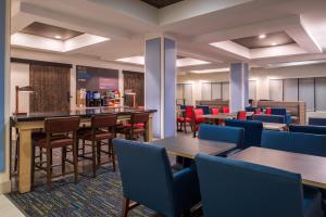 a restaurant with tables and chairs and a bar at Holiday Inn Express Hotel & Suites Tampa-Anderson Road-Veterans Exp by IHG in Tampa