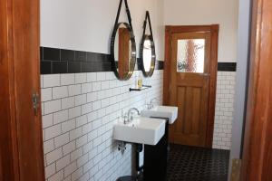 a bathroom with two sinks and two mirrors at Guildford Hotel in Guildford