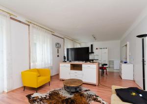 a living room with a yellow chair and a table at Apartments Andrijana in Rijeka