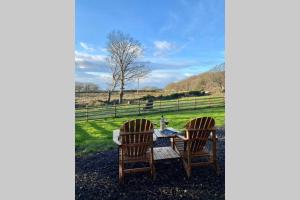 dwa krzesła i stół na polu w obiekcie Lle Mary - Beautiful views, Hot tub, Secluded, Dog Welcome, Barmouth w mieście Llanddwywe +31 zdjęć