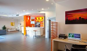 a lobby with a bar with a computer on a desk at Holiday Inn Express Reggio Emilia by IHG in Reggio Emilia