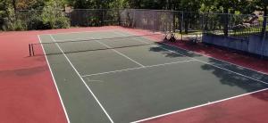 a tennis court with a net on top of it at Unit 51 - Treeloft 3 Bedroom Villa in Four Seasons