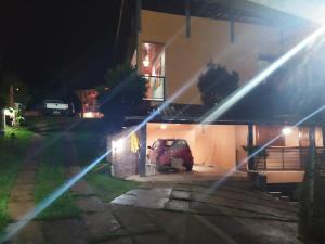 a car parked in front of a house at night at Suites Cantinho de MInas in Lavras Novas