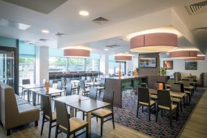 a restaurant with tables and chairs and a bar at Holiday Inn Express Middlesbrough - Centre Square by IHG in Middlesbrough