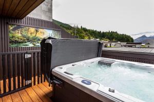 a hot tub on the balcony of a house at Distinctive Alpine Meadows in Queenstown