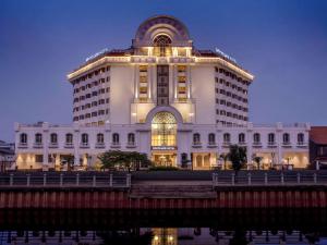 a large white building next to a body of water at Mercure Jakarta Batavia in Jakarta