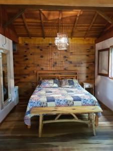 a bedroom with a bed in a log cabin at Chalés Mathora in Visconde De Maua