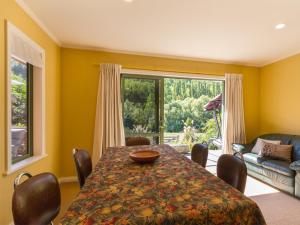 a dining room with a table and a large window at Sawmillers Retreat - Arrowtown Holiday Home in Arrowtown +18 photos