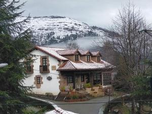 una casa cubierta de nieve en una montaña en La Riguera De Ucieda, en Ucieda de Arriba