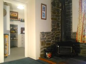 uma sala de estar com lareira e uma parede de pedra em Ezy Walk - Blenheim Holiday Home em Blenheim