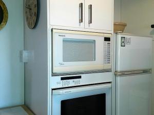 uma cozinha com um micro-ondas por cima de um forno em Ezy Walk - Blenheim Holiday Home em Blenheim