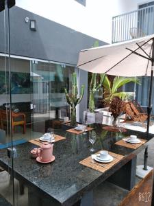 a table with cups and plates and an umbrella at Villa Maria in Capitólio