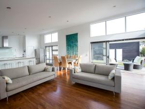 un salon avec deux canapés et une cuisine dans l'établissement Waikanae Retreat - Waikanae Beach Holiday Home, à Waikanae 13 autres photos