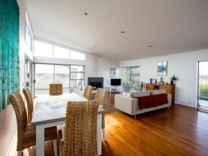 a living room with a table and chairs and a couch at Waikanae Retreat - Waikanae Beach Holiday Home in Waikanae