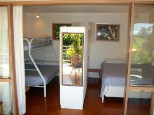 een kamer met een stapelbed en een deur met een spiegel bij Bush Beach Delight - Onetangi Holiday Home in Onetangi