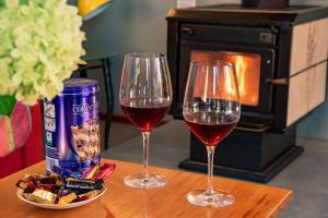 two glasses of wine and a plate of food on a table at HH Akaroa - Akaroa Holiday Home in Akaroa