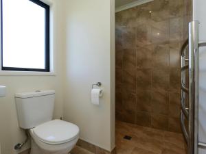 une salle de bain avec toilettes et douche dans l'établissement Te Awa Napier Treasure - Napier Holiday Home, à Napier 13 autres photos