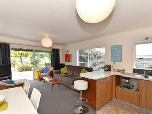 a kitchen and living room with a couch at Blue Lagoon - Kaiteriteri Holiday Unit in Kaiteriteri