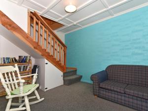 sala de estar con sofá y escalera en Blue Lagoon - Kaiteriteri Holiday Unit, en Kaiteriteri