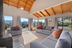 a living room with two couches and a fireplace at Sycamore Place - Wanaka Holiday Home in Wanaka