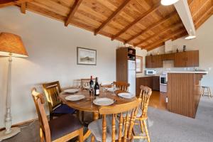 a kitchen and dining room with a table and chairs at Sycamore Place - Wanaka Holiday Home in Wanaka