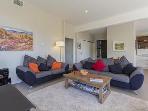 a living room with two couches and a coffee table at Sunhaven Lakeside - Cromwell Holiday Home in Cromwell +19 photos