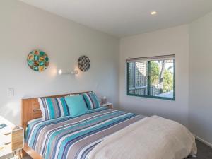 Schlafzimmer mit einem Bett und einem Fenster in der Unterkunft Beachfront Getaway - Waikanae Beach Holiday Home in Waikanae