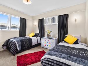 a bedroom with two beds and a window at Lake Shores Cottage - Hannahs Bay Holiday Home in Rotokawa