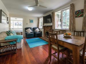 a living room with a table and a couch at Onetangi Beach Cottage - Onetangi Bach in Onetangi