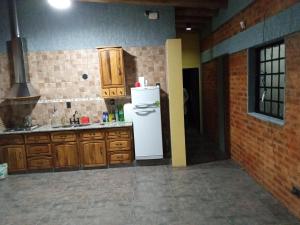 uma cozinha com um frigorífico branco e armários de madeira em Sueños de Amor em San Carlos