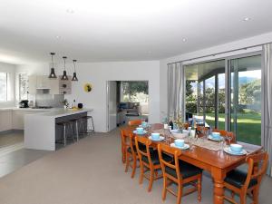 uma sala de jantar e cozinha com mesa e cadeiras de madeira em Marlborough Magic - Rapaura Holiday Home em Blenheim