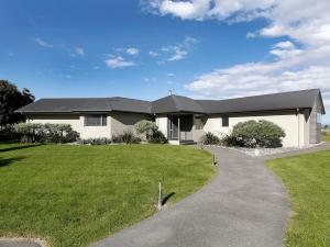 una casa blanca con techo negro y patio en Marlborough Magic - Rapaura Holiday Home en Blenheim