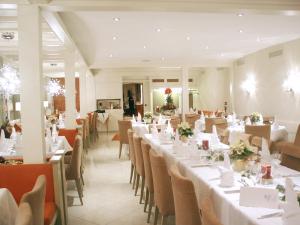 een eetkamer met witte tafels en stoelen bij Hotel-Restaurant-Kolb in Illertissen