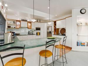 a kitchen with a counter and stools in it at Kawarau Bay View - Cromwell Holiday Home in Cromwell