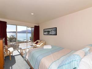 1 dormitorio con 2 camas y vistas al océano en Ngaire's Haven - Mahau Sound Holiday Home, en Ohingaroa