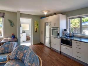 a kitchen with white cabinets and a counter top at Bay Bliss - Akaroa Holiday Home in Akaroa +13 photos