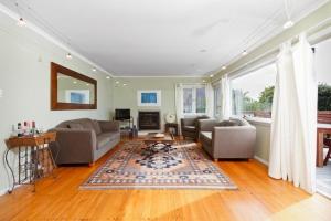 uma sala de estar com um sofá e uma mesa em Beach House - Paraparaumu Beach Holiday Home em Paraparaumu Beach