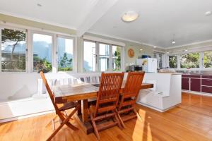 uma cozinha com uma mesa de madeira e cadeiras em Beach House - Paraparaumu Beach Holiday Home em Paraparaumu Beach