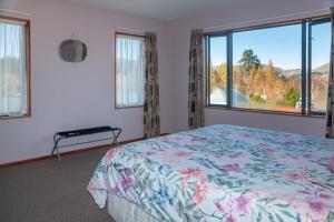 a bedroom with a bed and a large window at Hanmer's Rose - Hanmer Springs Holiday Home in Hanmer Springs