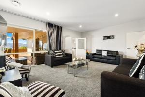 a living room with two couches and a table at Lakeside Luxury - Wanaka Holiday Home in Wanaka