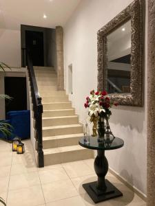 a staircase with a mirror and a table with flowers at Maison Pascual - Centro Histórico in San Luis Potosí