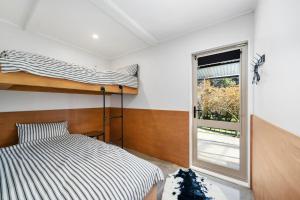 a bedroom with a bunk bed and a window at The Bunkhouse - The Lodge Te Horo in Te Horo