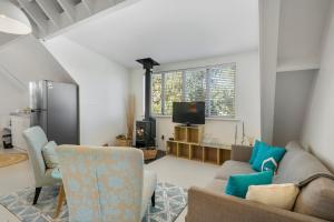 uma sala de estar com um sofá e uma televisão em The Apartment - The Lodge Te Horo em Te Horo