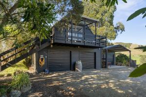 a house with a balcony on top of a garage at The Apartment - The Lodge Te Horo in Te Horo