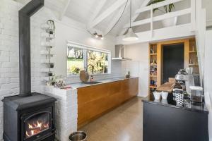 uma cozinha com lareira e fogão em The House - The Lodge Te Horo em Te Horo